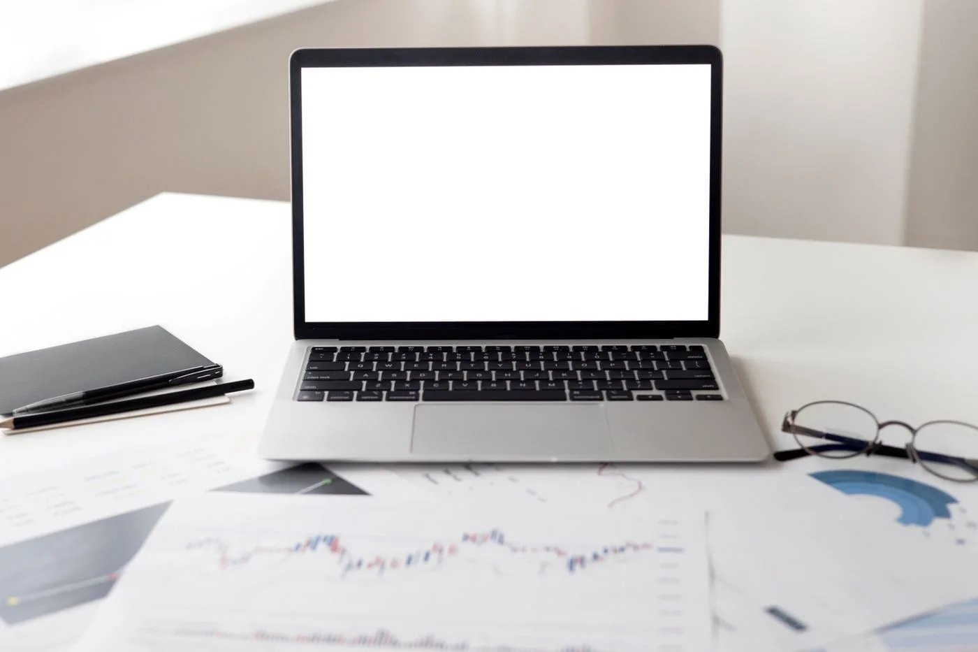 Open laptop with financial documents on a desk, ideal for business and technology themes.